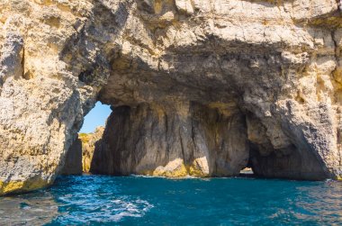 Comino adasında mağara. Kayalıklar ve mavi deniz. Malta 