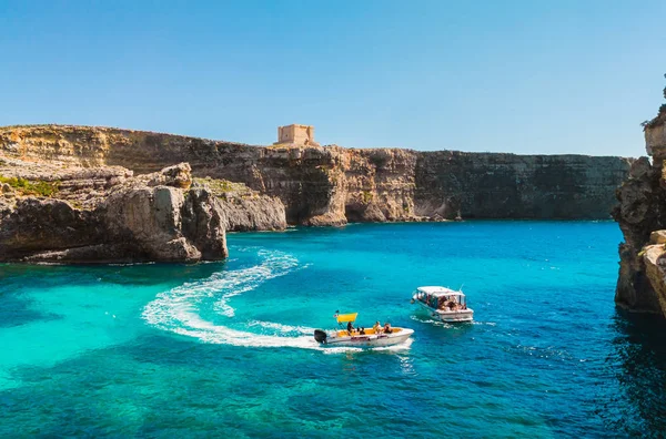 Comino adası. Kayalıklar, turistik tekneler ve mavi deniz. Malta ülkesi