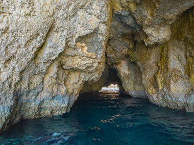 Comino adasında mağaradelik. Kayalıklar ve mavi deniz. Malta adası