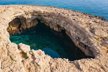 Kayada büyük bir doğal delik var. Mercan Lagünü. Malta adası