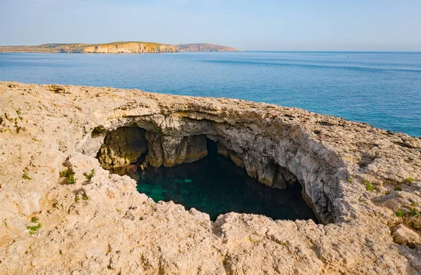Kayada büyük bir doğal delik var. Mellieha'daki Coral Lagünü. Malta 