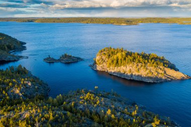 Ladoga skerries 'in hava görüntüsü. Günbatımı, sonbahar, mavi su. Karelia Cumhuriyeti 'ndeki Ladoga Gölü. Rusya