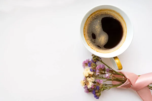 Cup of coffee with flowers and pink ribbon. Flat lay, top view. Valentines and 8 March Mother Women