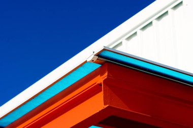 Turuncu ve beyaz modern çatı üst mavi gökyüzü arka planda bina.