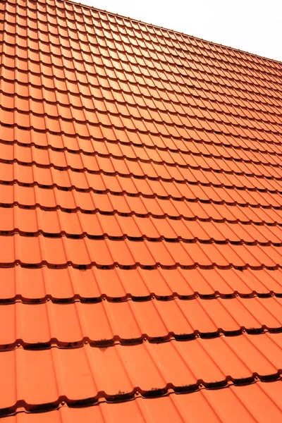 Orange concrete roof tiles on a residential home. Roof tiles background texture.