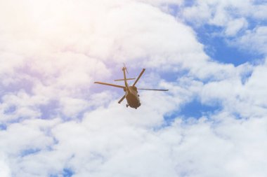 Güzel beyaz kabarık bulutlar arka plan ile mavi gökyüzünde uçan helikopter.