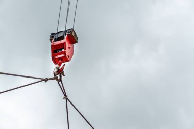 Bulutlar arka plan ile güneşli bir günde kırmızı kaldırma çelik vinç kanca, döner eklem ve bağlantı çelik askı ile Mobil inşaat vinçler. Yapıları açık havada monte eden mobil vinçler. İnşaat ve inşaat ekipmanları.