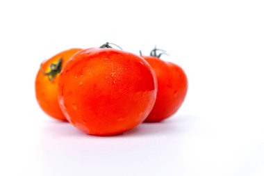 Beyaz arka planda izole kırmızı domates kapatın. Su damlacıkları ile Domates. Taze domates ler pişmeye hazır. Domates, C ve A vitamini içeren sebzelerdir. Ve ayrıca likopen Beta-karoten ve fosfor gibi anti-oksidanlar da var. 