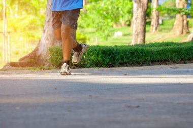 Asyalı Adam güneşli bir günde bir parkta koşu. Koşu ve Sağlıklı yaşam tarzı kavramı.
