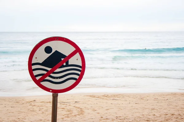 No swimming allowed sign at the beach with strong sea wave by the beach background. Do not swim sign because of high waves, strong winds, heavy rain or variable weather in Phuket beach, Thailand.