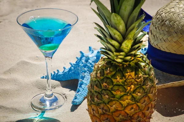 Pineapple and martini glass with blue cocktail on the background