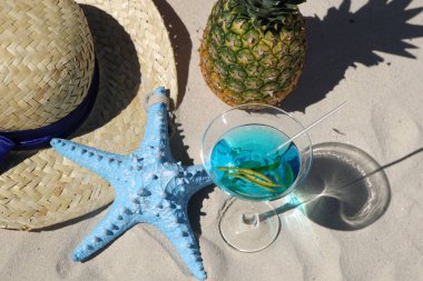 Kokteyl ananas ve kum üzerinde hasır şapka