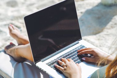 Serbest çalışan kadın laptop çalışma şezlong üzerinde