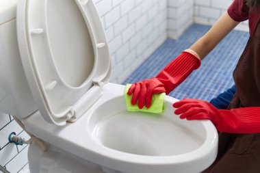 Asyalı kız kırmızı lastik eldivenli klozet tuvalet temizleme işlemi kullanarak temizliyor. O oturuyor ve banyo temizlik. Üst kısmı görünümünde gördün. Mutlu tuvalet temizlik kavramı.