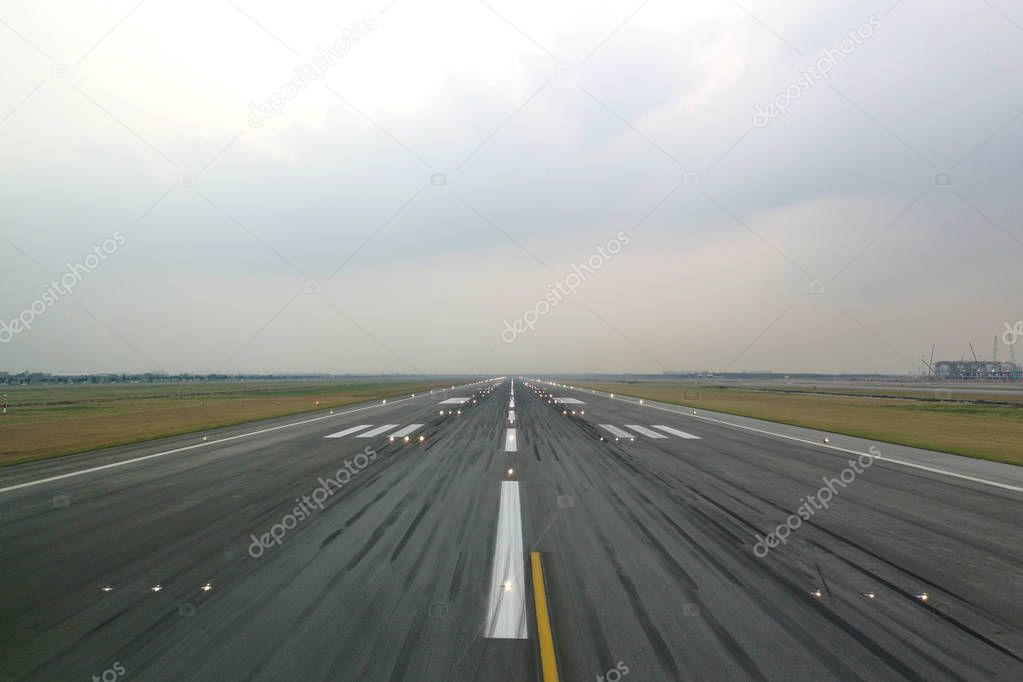 Airport runway in the evening with light system opened, ready for airplane landing or taking off. Seen from the airplane cockpit. Modern aviation concept.