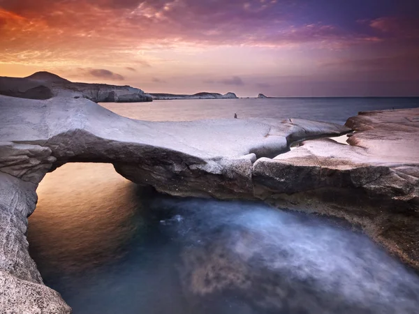 Güzel plaj, Sarakiniko, Milos Adası Yunanistan. Volkanik kayalar ile bir plajda renkli günbatımı.