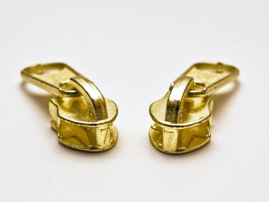 İki altın renkli fermuar kafaları.