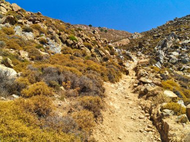 Sert manzara, toprak yolu çalı ve kayalar, sıcak yaz günü, Patmos adası, Yunanistan.
