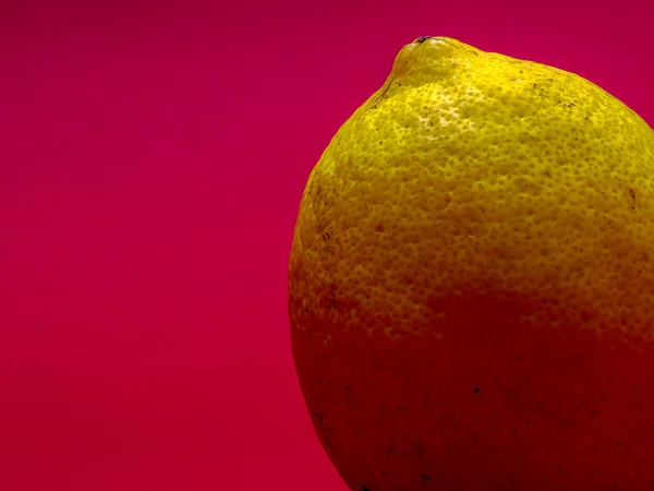 One single lemon isolated on magenta  background.