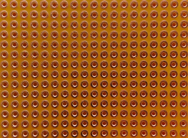 Empty pcb board with copper coated holes for diy electronic projects. Close up seamless background.