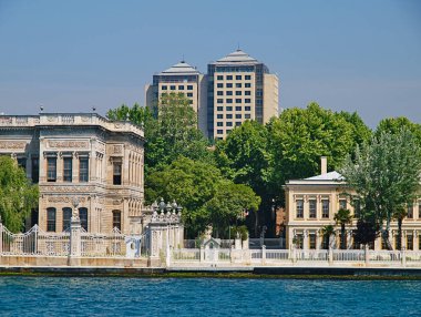 Dolmabahçe Sarayı'nın dış cephesi ve gökdelenleri denizden manzaraya sahiptir. İstanbul, Türkiye.