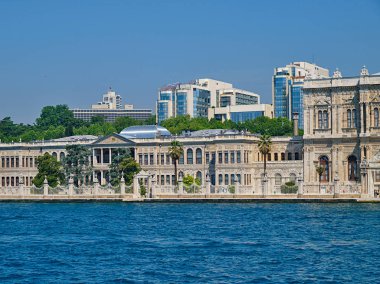 Dolmabahçe Sarayı'nın dış cephesi ve gökdelenleri denizden manzaraya sahiptir. İstanbul, Türkiye.