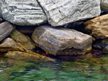 Güzel dokulu kayalar detay yakın deniz, Tinos adası, Yunanistan üzerinde yığılmış.