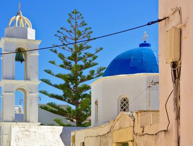 Mavi kubbe, çan kulesi ve çam ağacı ile güzel tipik Kiklad beyaz şapel, Tinos adası, Yunanistan.