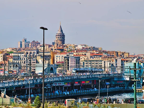 İstanbul, Türkiye - 24.05.2010: Galata köprüsü, Boğaz'da balık avlama, köprü altında kafe ve restoranlar ve İstanbul silueti, aydınlık bir gün.