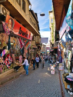 İstanbul, Türkiye - 24.05.2010: İstanbul pazar sokağında atkı dükkanları, asfalt zemin, gökyüzü manzarası, yerlihalk, ziyaretçiler ve alışverişçiler.