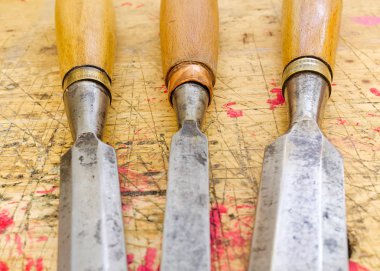 Ahşap tezgah grunge yüzeyinde izole üç antika ahşap keski.