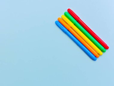 T için boş alan ile açık mavi arka plan üzerinde renkli işaretler