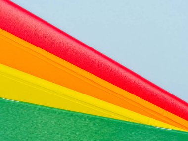 Renkli yığılmış dizüstü bilgisayarlar açık mavi arka planda kapanır.