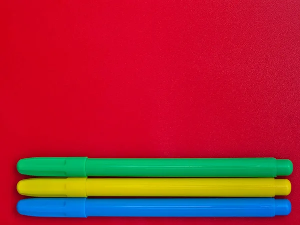 Tres Marcadores Colores Aislados Sobre Fondo Rojo Con Espacio Vacío —  Fotos de Stock