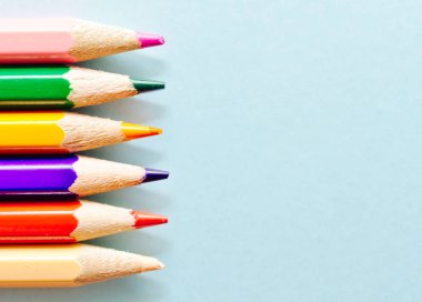 Renkli kalemler kopya alanı ile açık mavi arka plan üzerinde izole.