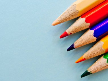 Renkli kalemler kopya alanı ile açık mavi arka plan üzerinde izole.