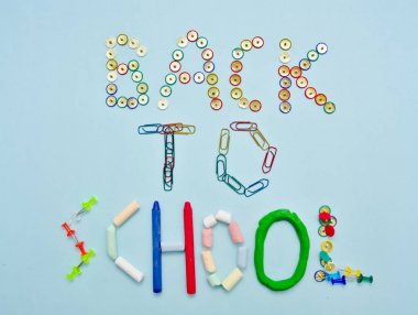 Açık mavi arka plan aleyhine renkli okul suplies ile yapılan okul metnine geri dön.