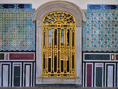 İstanbul Topkapı Sarayı'nda kiremitli duvarda altın korkuluklar ve klasik oryantal tasarımlı pencere.