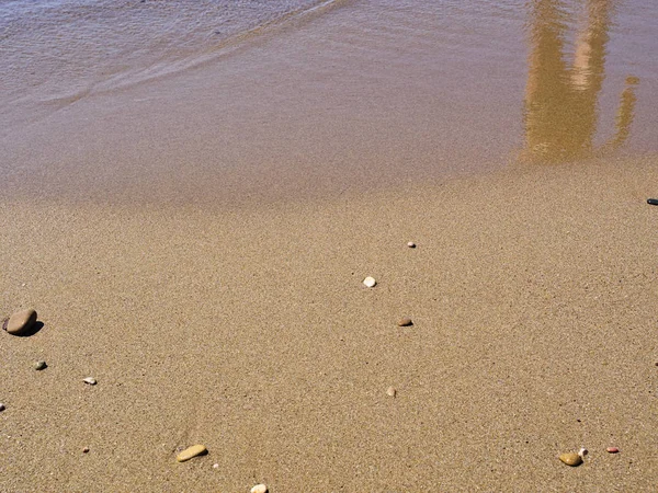 Mänsklig figur reflektion på sandstrand yta. — Stockfoto