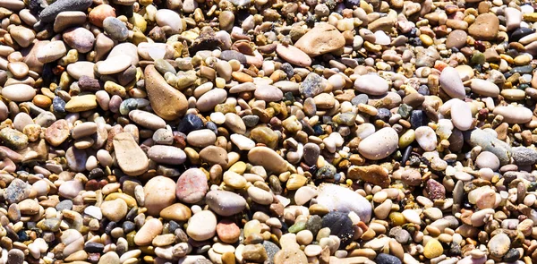 ビーチカラフルな小石は パノラマの背景を閉じます — ストック写真