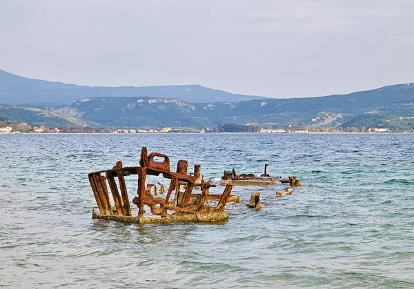Naufragio de barco oxidado en agua de mar ondulada, laguna Gialova, Peloponeso — Foto de Stock