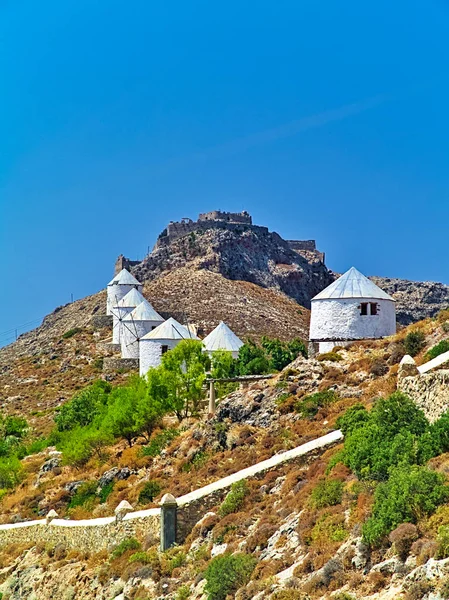 Yunanistan 'ın Leros adasındaki bir tepede güzel beyaz yel değirmenleri. Tepedeki Panteli ya da Panteliou Ortaçağ Şatosu.