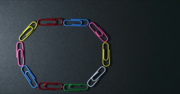 Stop motion of paper clips creaing shapes and symbols — Stock Video