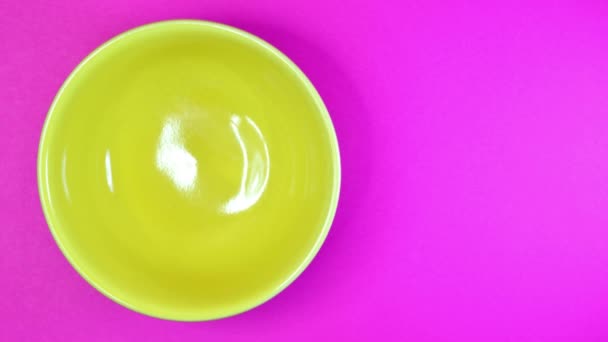 Stop motion of yellow bowl with black beans on color background — Stock Video