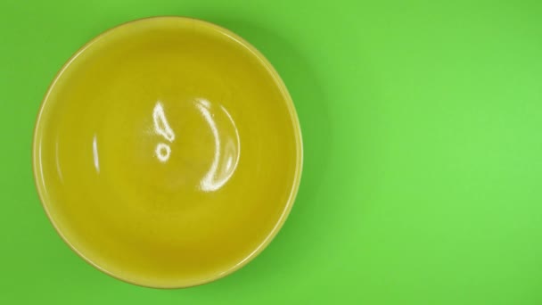 A sárga tálat megállíthatja a napraforgómaggal, színes háttérrel — Stock videók