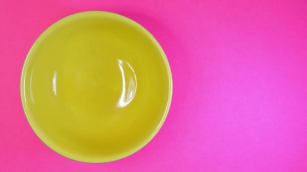 停止黄色碗在颜色背景上的运动与爆米花仁 — 图库视频影像