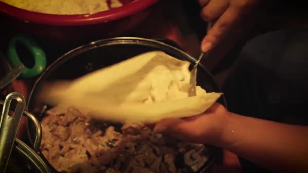 Mujer preparando un tamal de chile con salsa roja y queso — Vídeos de Stock