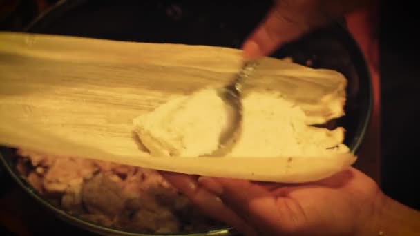 Kvinna förbereder en grön sås Tamale med fläsk kött och bönor — Stockvideo