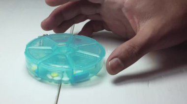 Kişi plastik Pills kutusundan bir hap Taking