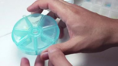 Kişi plastik Pills kutusundan dört hap Taking